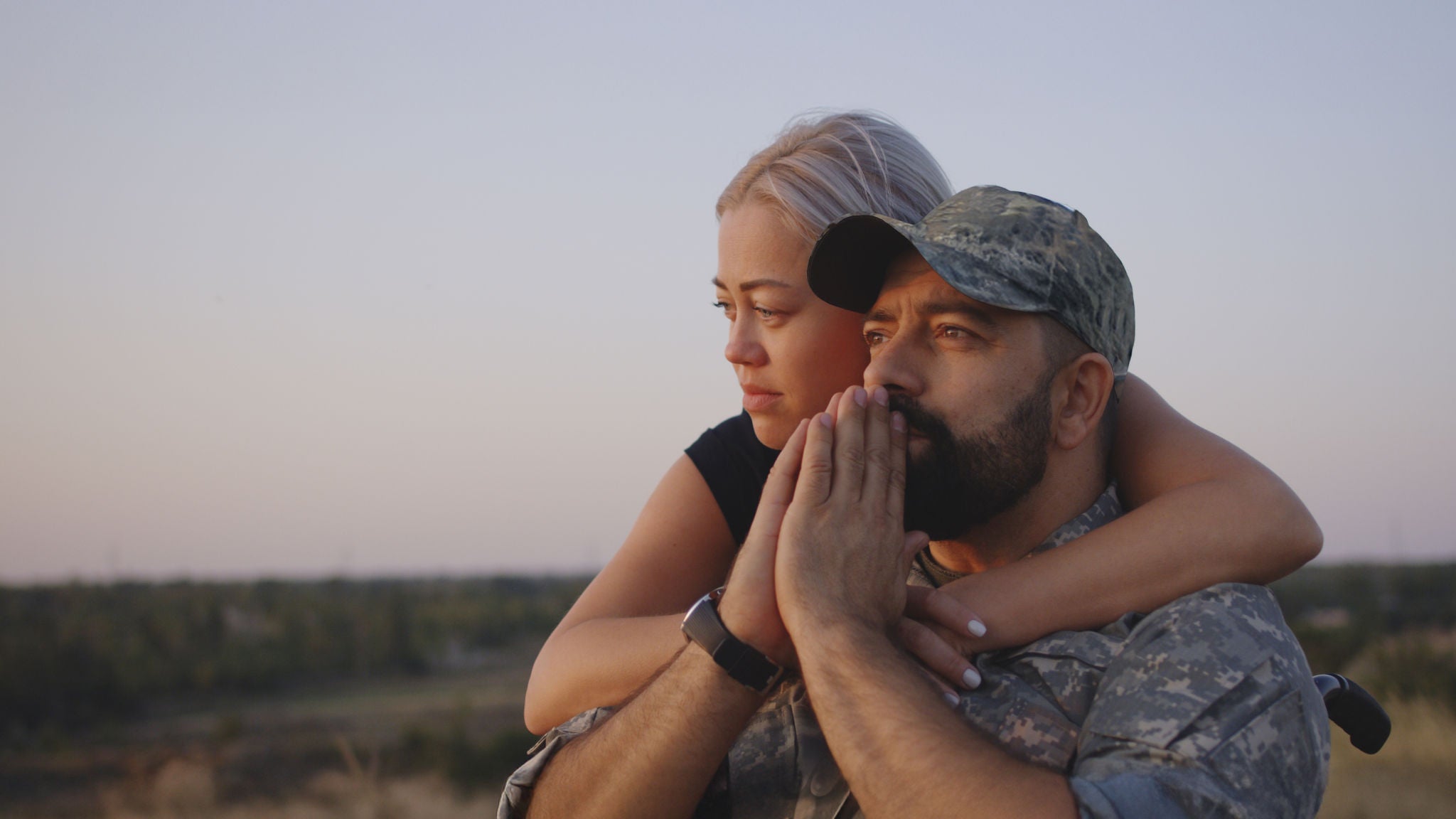 1177656605 Medium close-up of wife hugging wheelchaired soldier husband